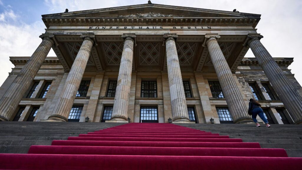 Looking up to a Grecian inspired concert hall with a red carpet down the external stairs