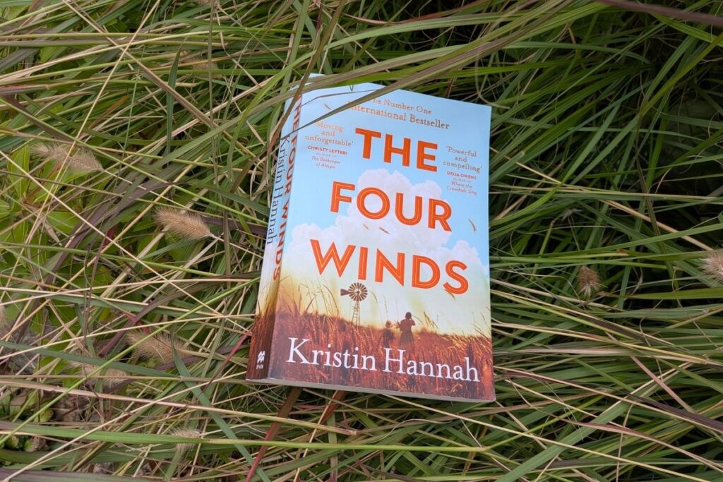 The Four Winds by Kristin Hannah sitting in tall grass